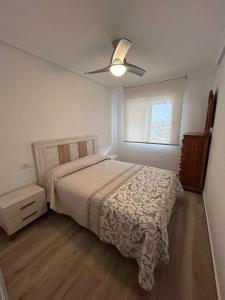 a bedroom with a bed and a ceiling fan at Vive Santa Pola - Relax y tranquilidad junto al mar in Santa Pola