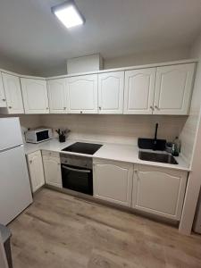 a white kitchen with white cabinets and a sink at Vive Santa Pola - Relax y tranquilidad junto al mar in Santa Pola