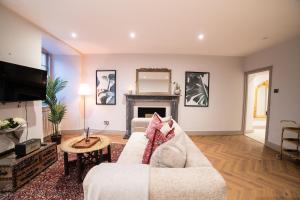 Una sala de estar con un sofá y una chimenea. en The Kings Courtyard Apartment, en Bath