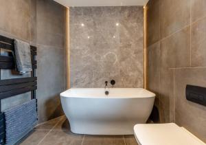 a bathroom with a white tub and a toilet at Newly Renovated luxury seaside property with hot tub - near to Cromer & Sheringham in West Runton +47 photos