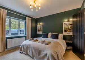 a bedroom with a large bed with green walls at Newly Renovated luxury seaside property with hot tub - near to Cromer & Sheringham in West Runton