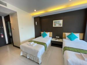 two beds in a hotel room with blue pillows at My PLACE HUA-HIN HOTEL in Hua Hin +12 photos