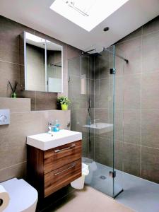a bathroom with a sink and a glass shower at Luxury Hampstead Mews House, Close to City Centre in London