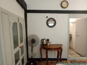 a room with a table and a clock on the wall at Labboo'z Café and Lodge in Maheshwar