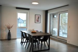 a dining room with a wooden table and chairs at Appartement Deluxe in Vaux-sur-Sûre