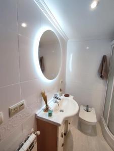 a bathroom with a sink and a toilet and a mirror at Piso centro A Coruña in A Coruña