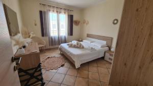 a bedroom with a white bed and a window at Sweet House in Villasimius