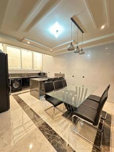 ein Esszimmer mit einem Glastisch und schwarzen Stühlen in der Unterkunft Fez Spacious Stay with Moroccan Artisanal Charm in Fès + 13 Fotos