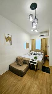 a bedroom with a bed and a couch and a table at Getaway Gem in the City - Ann's Residences in Lapu Lapu City