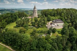 eine Luftansicht eines Gebäudes auf einem Hügel mit Bäumen in der Unterkunft Berghotel Eisenach in Eisenach