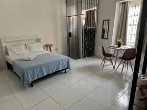 a bedroom with a bed and a table and chairs at São Francisco Aparts in Salvador