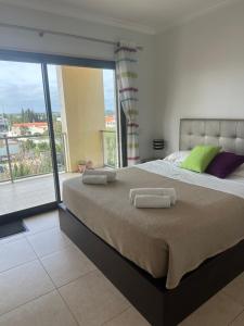 ein Schlafzimmer mit einem großen Bett mit zwei Handtüchern darauf in der Unterkunft Jardins da guia in Albufeira