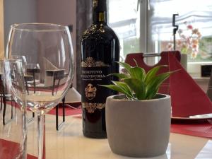 a bottle of wine and a potted plant on a table at Ferienhaus BellaVita in Walkenried