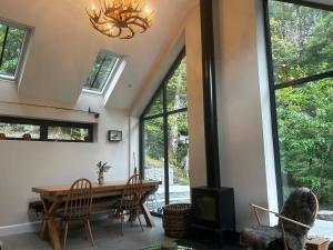 a dining room with a table and chairs and a chandelier at Aldernaig Mill in Invergarry