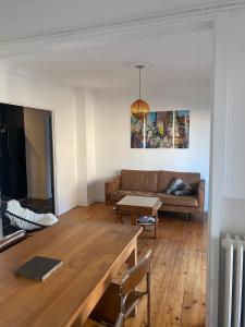 a living room with a couch and a table at Le Flow d'Issoire - Charmant appartement avec terrasse in Issoire