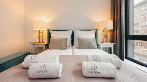 a bedroom with a bed with two pillows and a window at Flatbook - City Center Apartment Bank Polsk in Gdynia