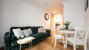 a living room with a green couch and a table at Flatbook - City Center Apartment Bank Polsk in Gdynia