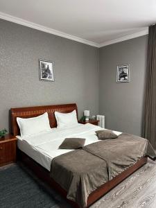 a bedroom with a large bed with white sheets at Deluxe SPA-Hotel in Ustʼ-Kamenogorsk +39 photos