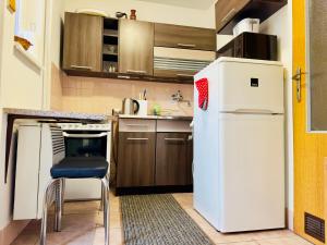 a small kitchen with a white refrigerator and a chair at Privát Ruženka in Liptovský Mikuláš