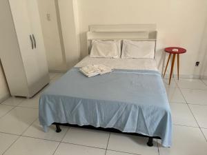 a bedroom with a bed with a blue blanket at São Francisco Aparts in Salvador