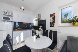 eine Küche und ein Esszimmer mit Tisch und Stühlen in der Unterkunft Apartment Tafra 2 in Lokva Rogoznica + 13 Fotos