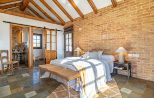 a bedroom with a large bed and a brick wall at Beautiful Home In Conil De La Frontera in Conil de la Frontera