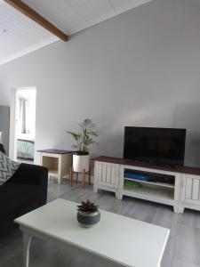 a living room with a flat screen tv on a table at Marina Cottage in Marina Da Gama