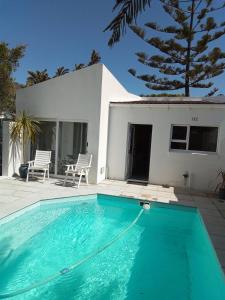 a swimming pool in front of a house at Marina Cottage in Marina Da Gama