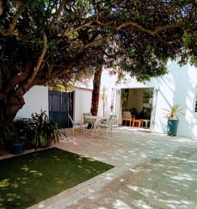a patio with a tree and a table and chairs at Marina Cottage in Marina Da Gama