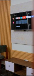 a microwave hanging on a wall with a wooden table at GNj HOMES in Sisa