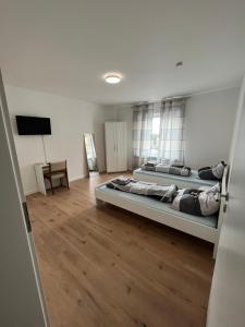 two beds in a large room with wooden floors at Übernachtung by Tag in Kassel