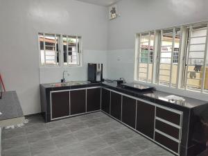 a kitchen with two sinks and two windows at DeStay Taiping in Taiping