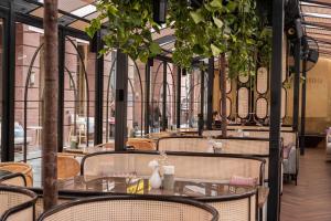 a restaurant with tables and chairs and plants at Donald Hotel in Odesa