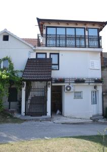 a white house with a gate and a balcony at Ruralna kuća za odmor Didovina Sinj in Sinj