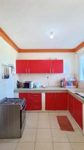 a kitchen with red cabinets and a stove at GashHomestay Mtwapa Luxury in Mtwapa