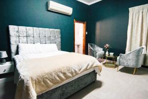 a bedroom with a bed and a blue wall at Skypz Home Lodge in Johannesburg +5 photos