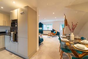 a kitchen and living room with a table and chairs at Huge Monthly Savings - Private Parking - WiFi in Gloucester
