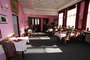 a dining room with tables and chairs and pink walls at Hotel Šrejber in Červený Kostelec