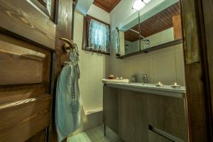 a bathroom with a sink and a towel on a door at Pounda Paou in Metókhion