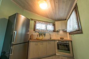 a kitchen with a stainless steel refrigerator and a window at Pounda Paou in Metókhion