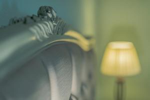 a headboard of a bed next to a lamp at Pounda Paou in Metókhion