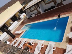 an overhead view of a swimming pool with white lounge chairs and a swimming pool at Club JM Lanzarote in Tabayesco