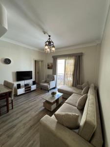 a living room with a couch and a television at Apartment with private Beach in Sahl Hasheesh in Hurghada