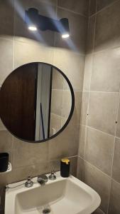 a bathroom with a sink and a mirror at Frenta al mar, vista a la playa in Mar del Plata