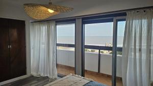a bedroom with a large window with a view of the ocean at Frenta al mar, vista a la playa in Mar del Plata