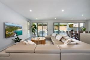 a living room with a large couch and a table at Casablanca Luxury Retreat near Shellharbour Marina in Shellharbour