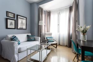 a living room with a white couch and a table at Apartamentos Edificio Constitución in Seville