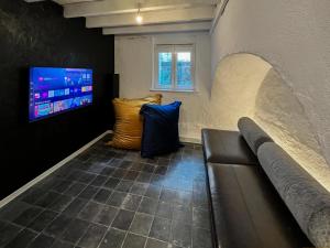 a waiting room with a couch and a tv at Guesthouse Josephine - Antwerpen in Antwerp
