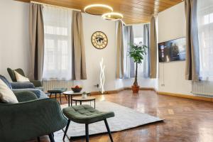 a living room with a couch and chairs and a clock at Cruwzo - Modern Centrally Located Apartment with Parking in Ingolstadt