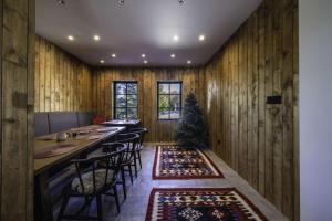 a dining room with wooden walls and a long table with chairs at Chalet 1600 Kopaonik & Spa in Kopaonik